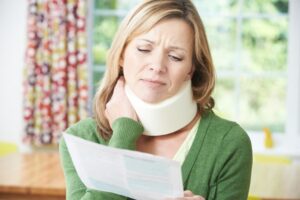 Woman reads letter after sustaining neck injury.