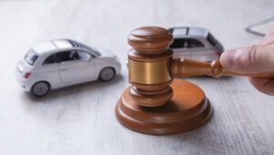 Car model and gavel symbolize accident lawsuit, insurance claim, or court case related to auto accident.