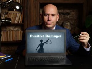 On a laptop screen, a sign indicates the business concept of punitive damages.