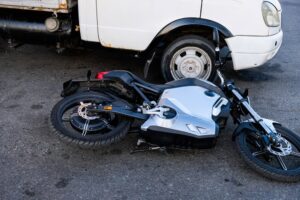 Collision between an electric motorcycle and a truck on the road.
